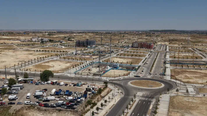 Fotos aéreas de Los Ahijones: la entrada del barrio con la rotonda y las promociones al fondo — 27 julio 2026