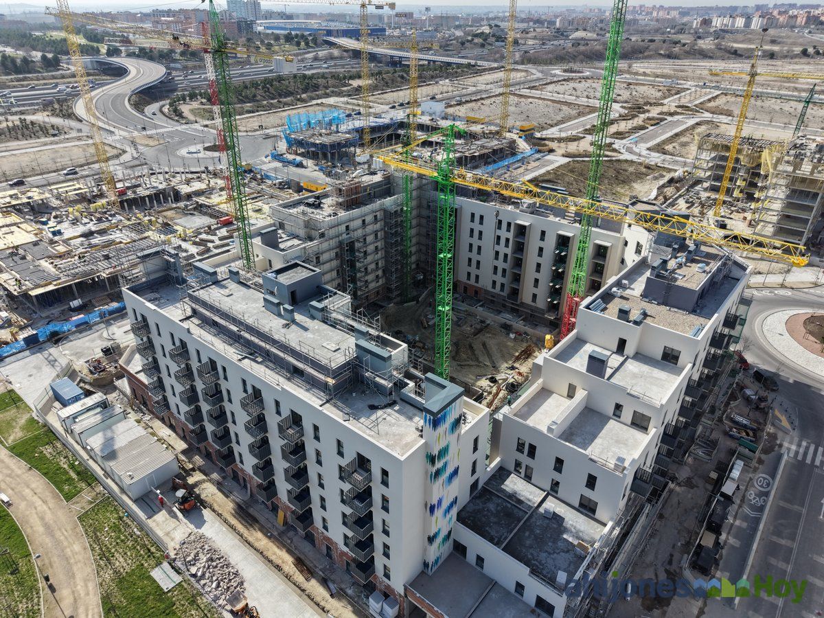 Edificios con fachadas blancas prácticamente terminados junto a grúas verdes